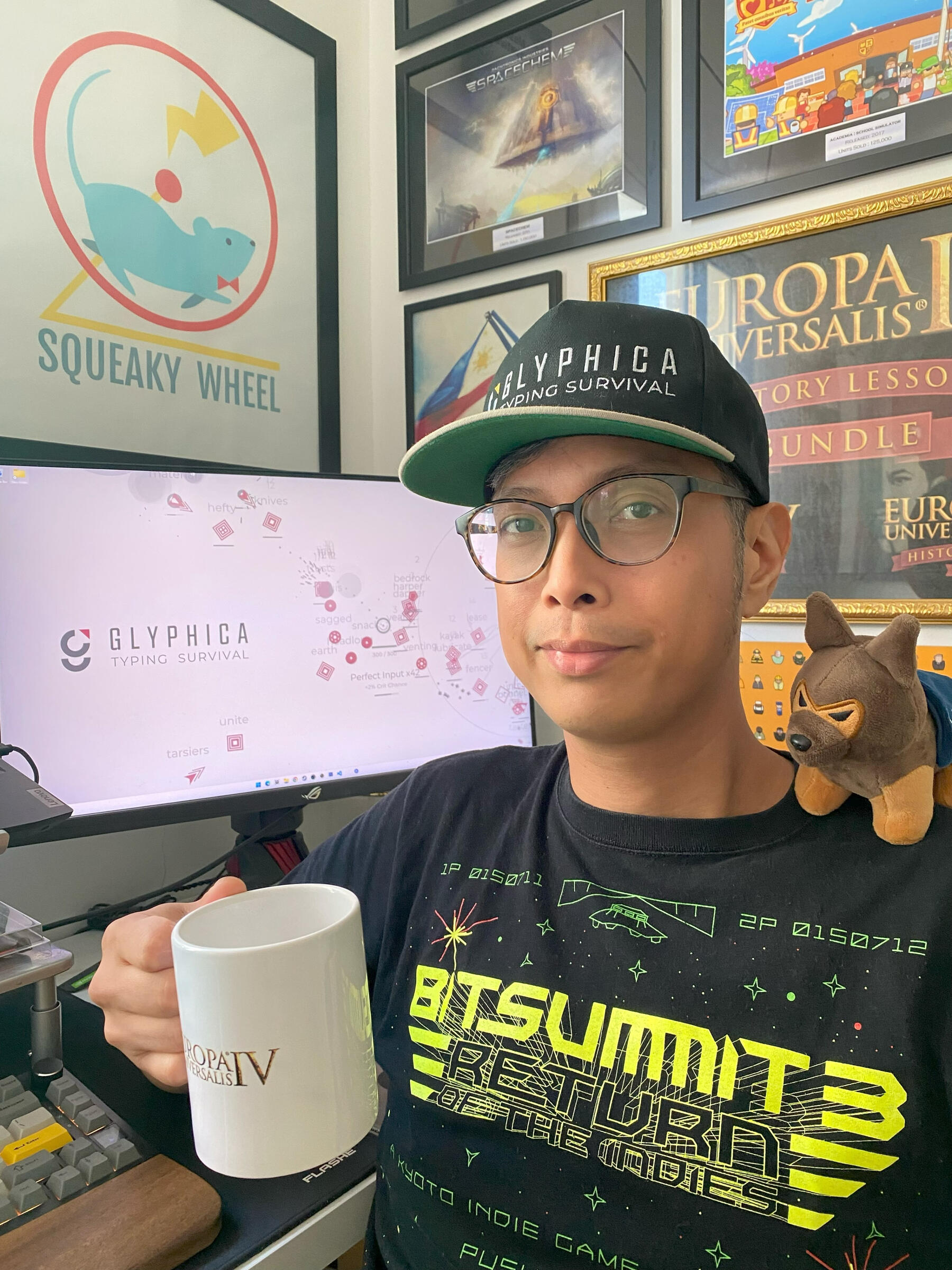 Image of Ryan Sumo with artifacts from games he has worked on like Prison Architect, Europa Universalis, etc.